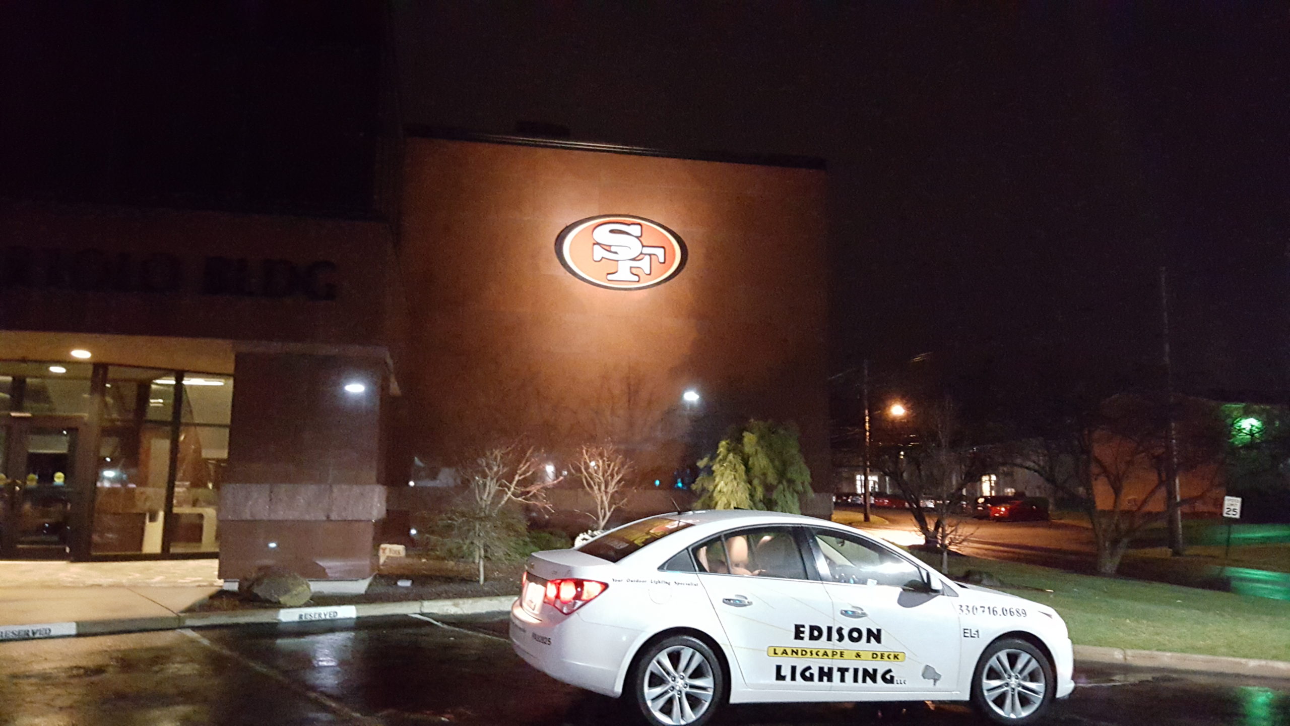 Debartolo building with illuminated 49ers sign with Edison car in parking lot