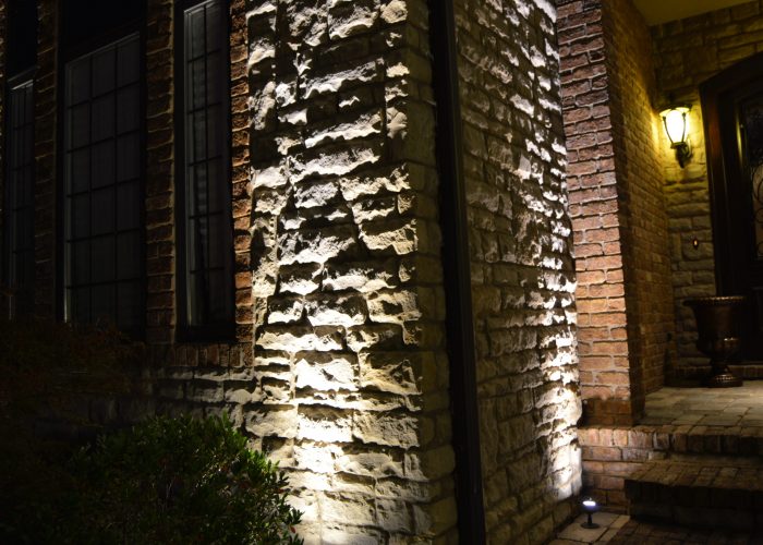 Accent lighting on brick siding of house