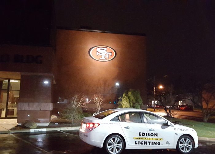 Debartolo building with illuminated 49ers sign with Edison car in parking lot